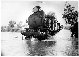 loco SAR T206 + another on goods train crossing flooded river - possible Central Australian Railway